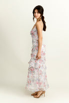 Side view of a woman wearing a purple floral dress on a white background