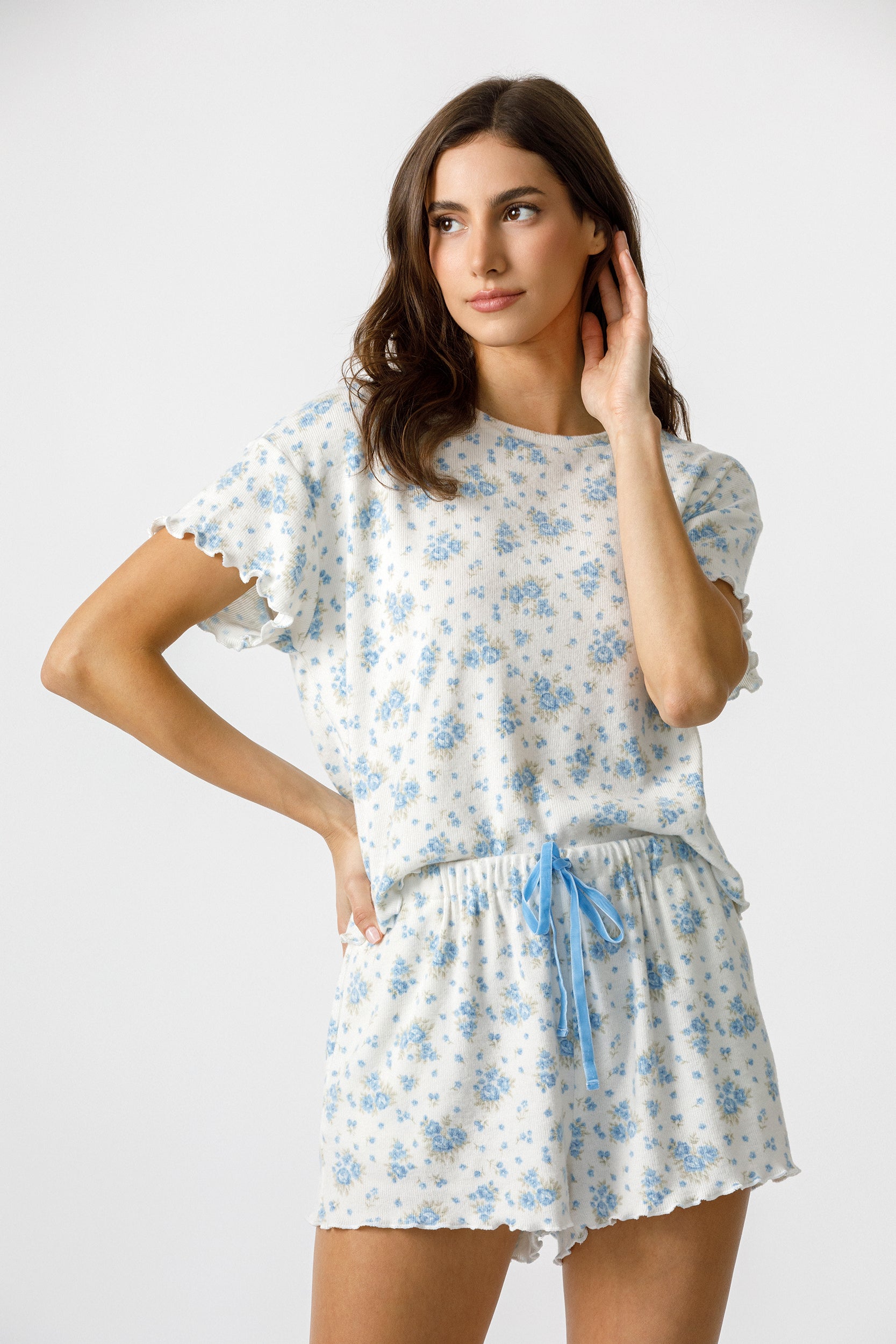 Woman wearing a white floral lounge set on a white background