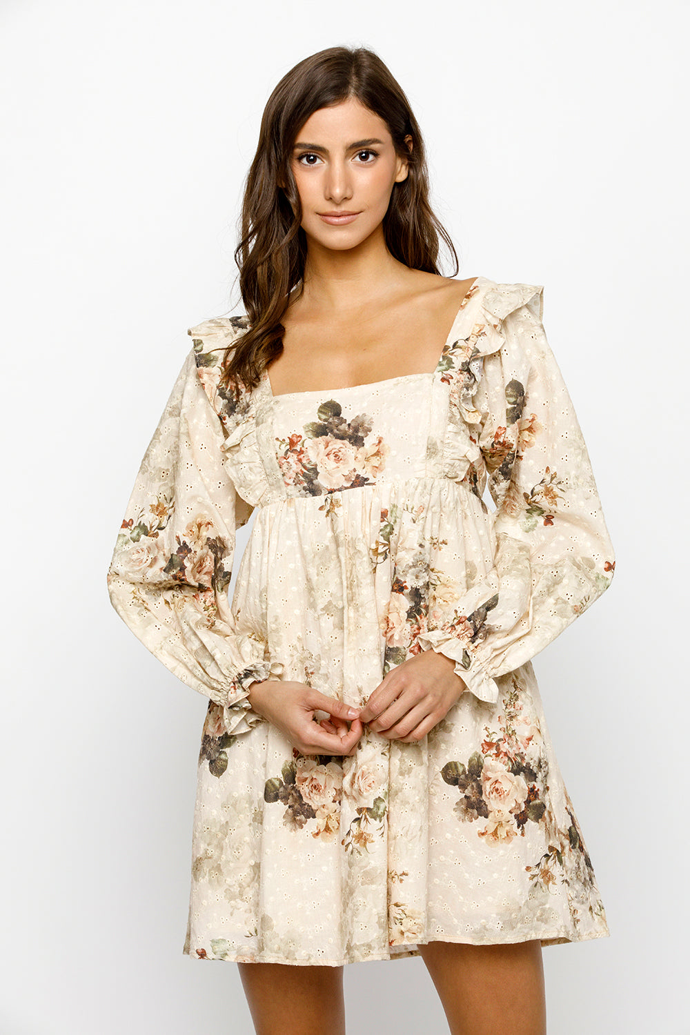 Woman wearing a beige floral mini dress against a white background