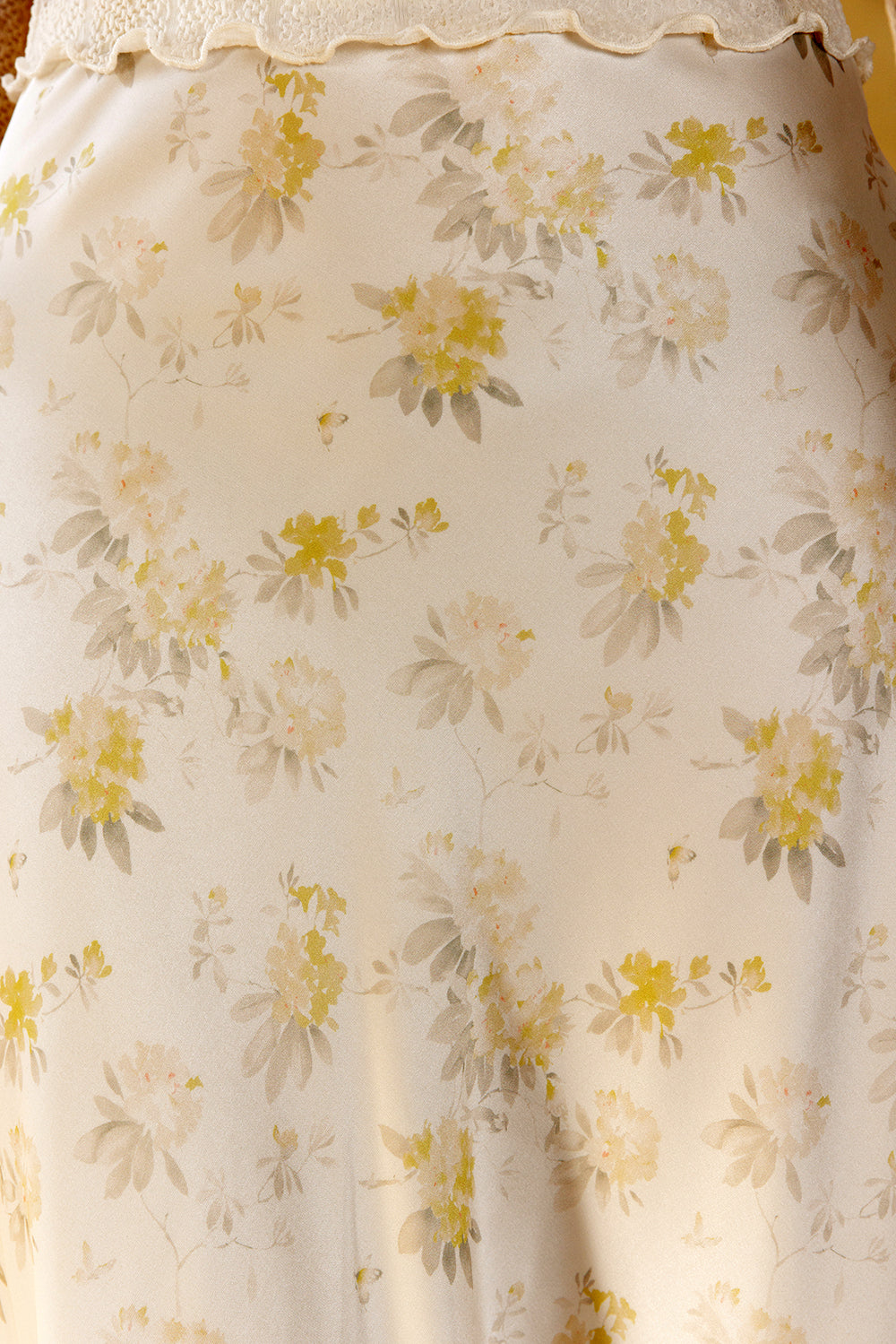 Floral patterned fabric with yellow and green flowers on a white background