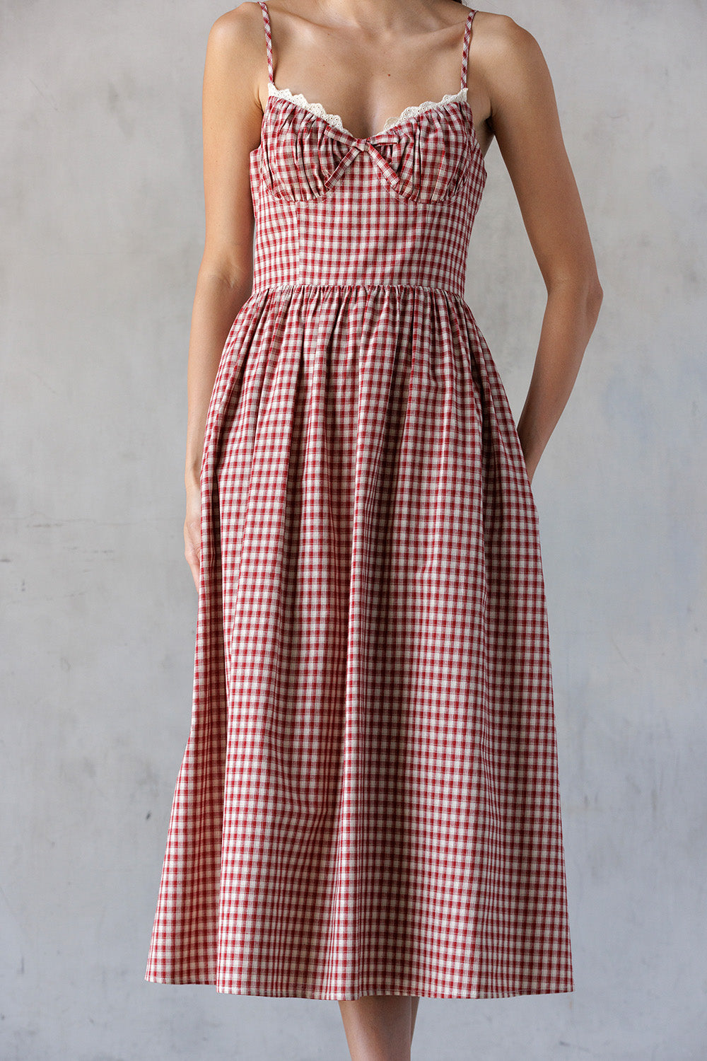 Red and white checkered dress worn by a person against a gray background