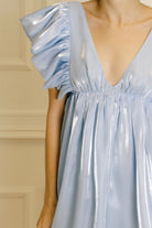 A light blue dress with ruffled sleeves against a neutral background