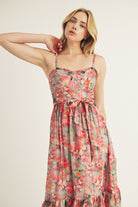 A woman wearing a pink watercolor rose print midi dress