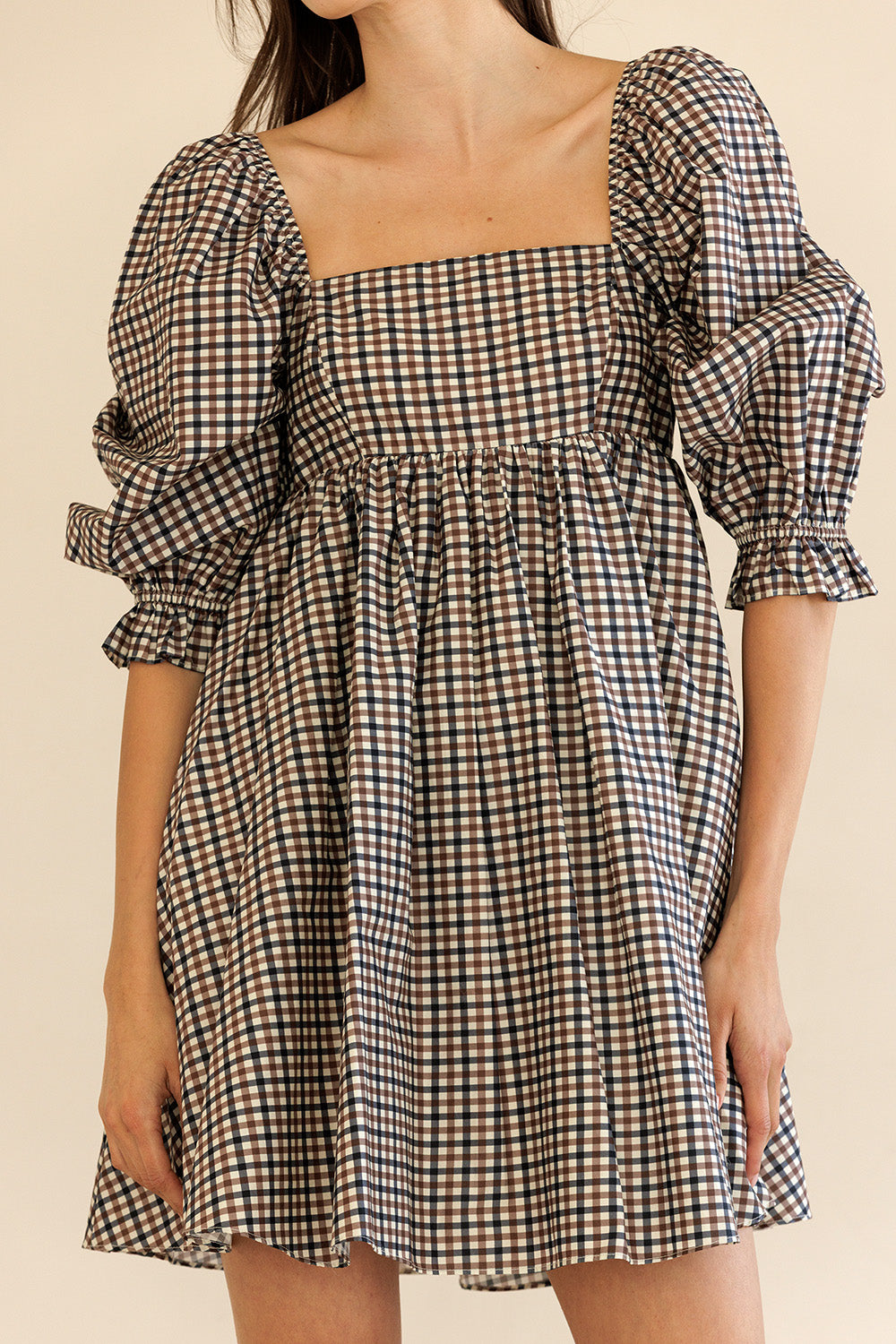 Checkered dress with puff sleeves on a plain background