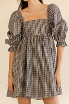 Checkered dress with puff sleeves on a plain background