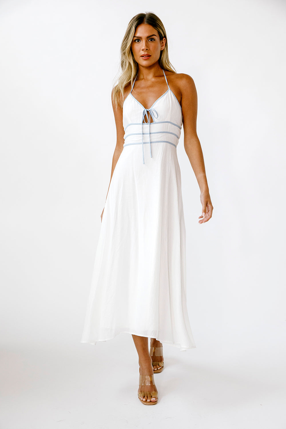 Woman wearing a white dress with blue accents on a white background