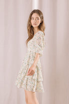 Woman wearing a floral dress against a plain background
