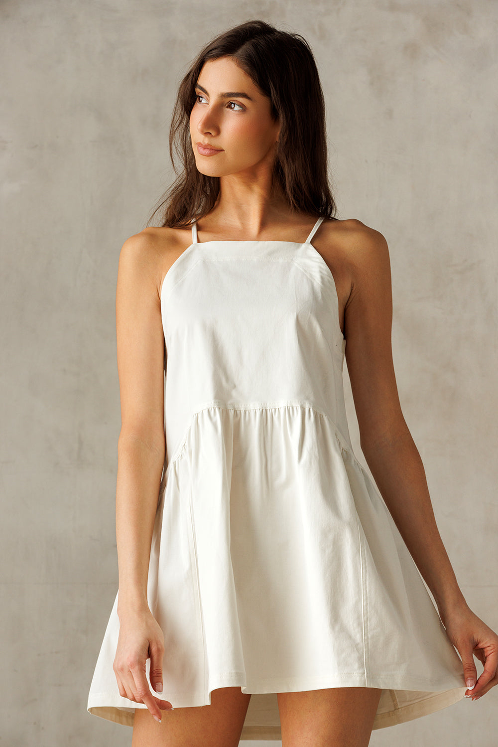Woman wearing a white dress against a plain background