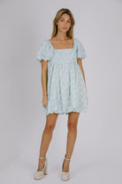Woman wearing a light blue floral dress on a white background