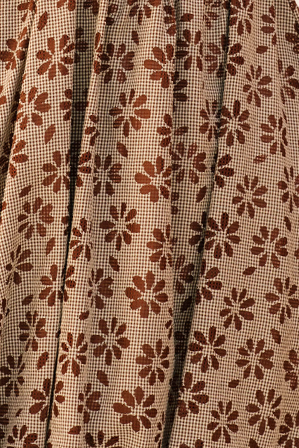Close-up of fabric with brown gingham with floral embroidery