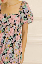Pastel floral dress against a beige wall