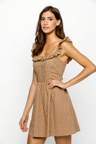 Woman wearing a beige and red floral mini dress on a white background