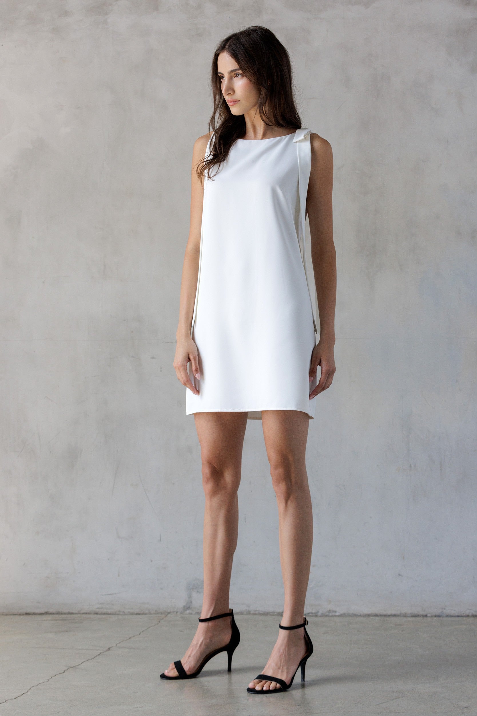 Woman wearing a white dress against a plain background