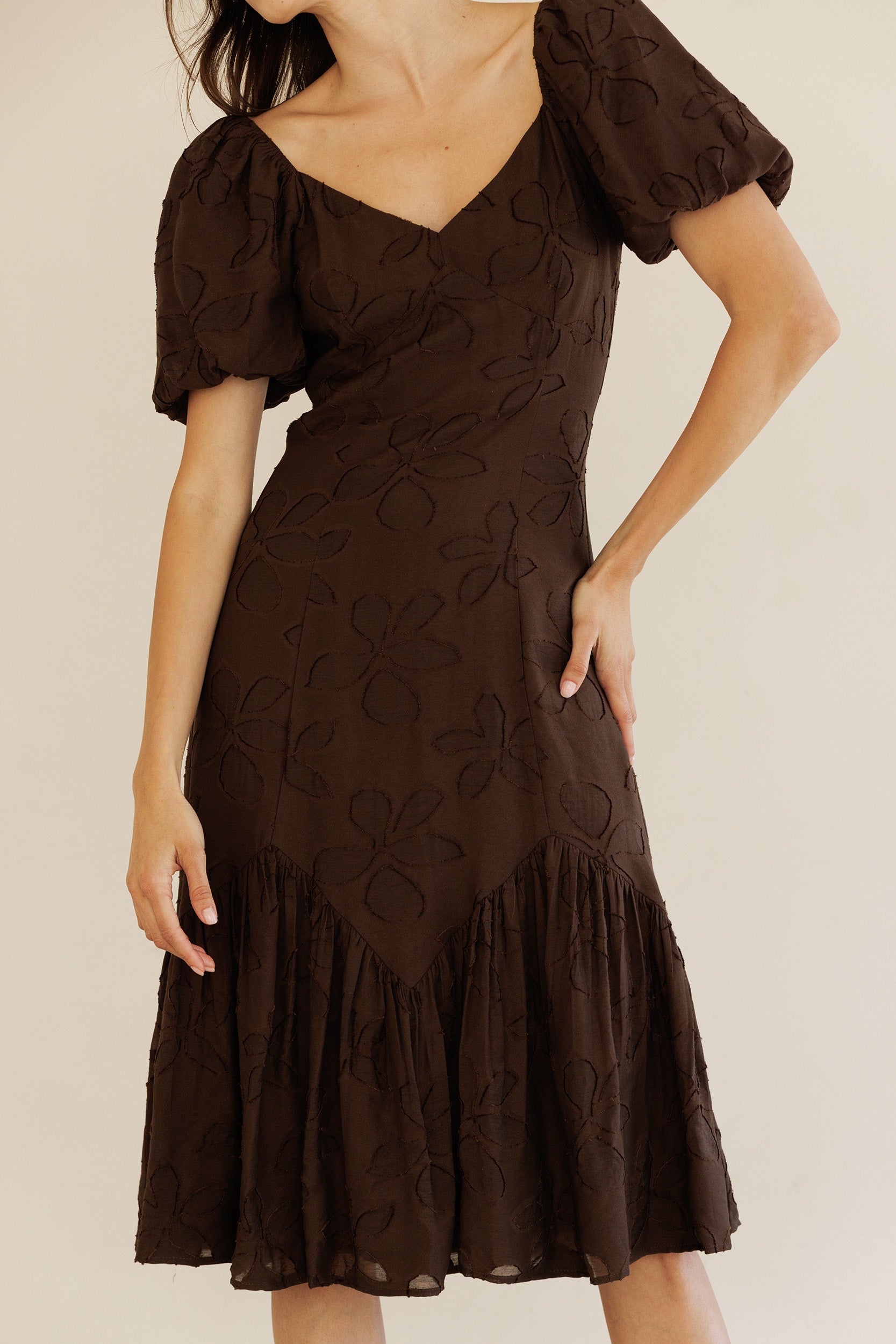 Brown dress with floral patterns on a plain background