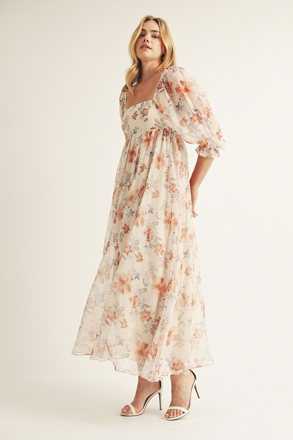 Woman wearing a beige floral dress on a white background