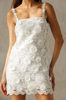 White lace dress worn by a person against a neutral background