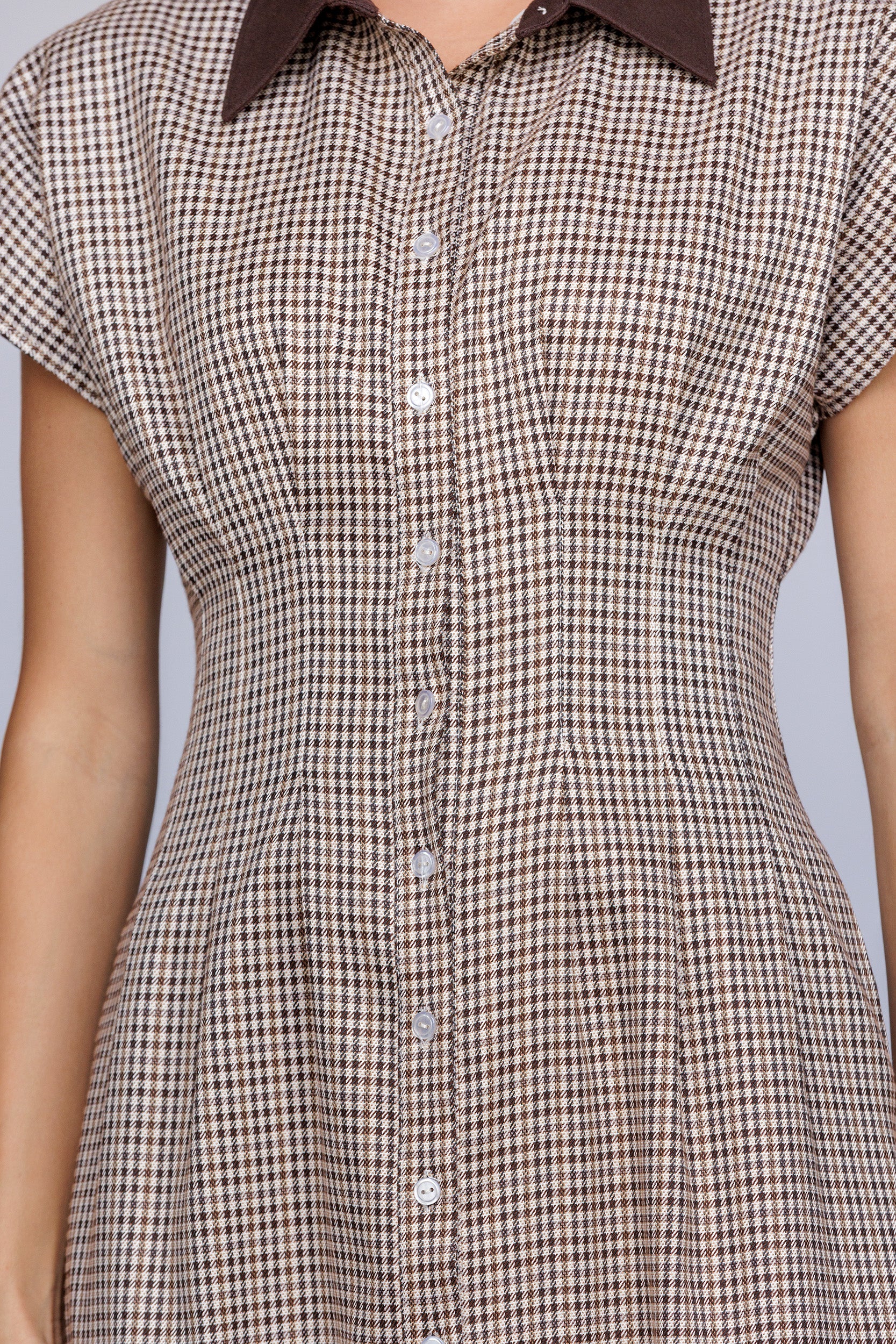 Brown and beige checkered dress with a collar on a gray background