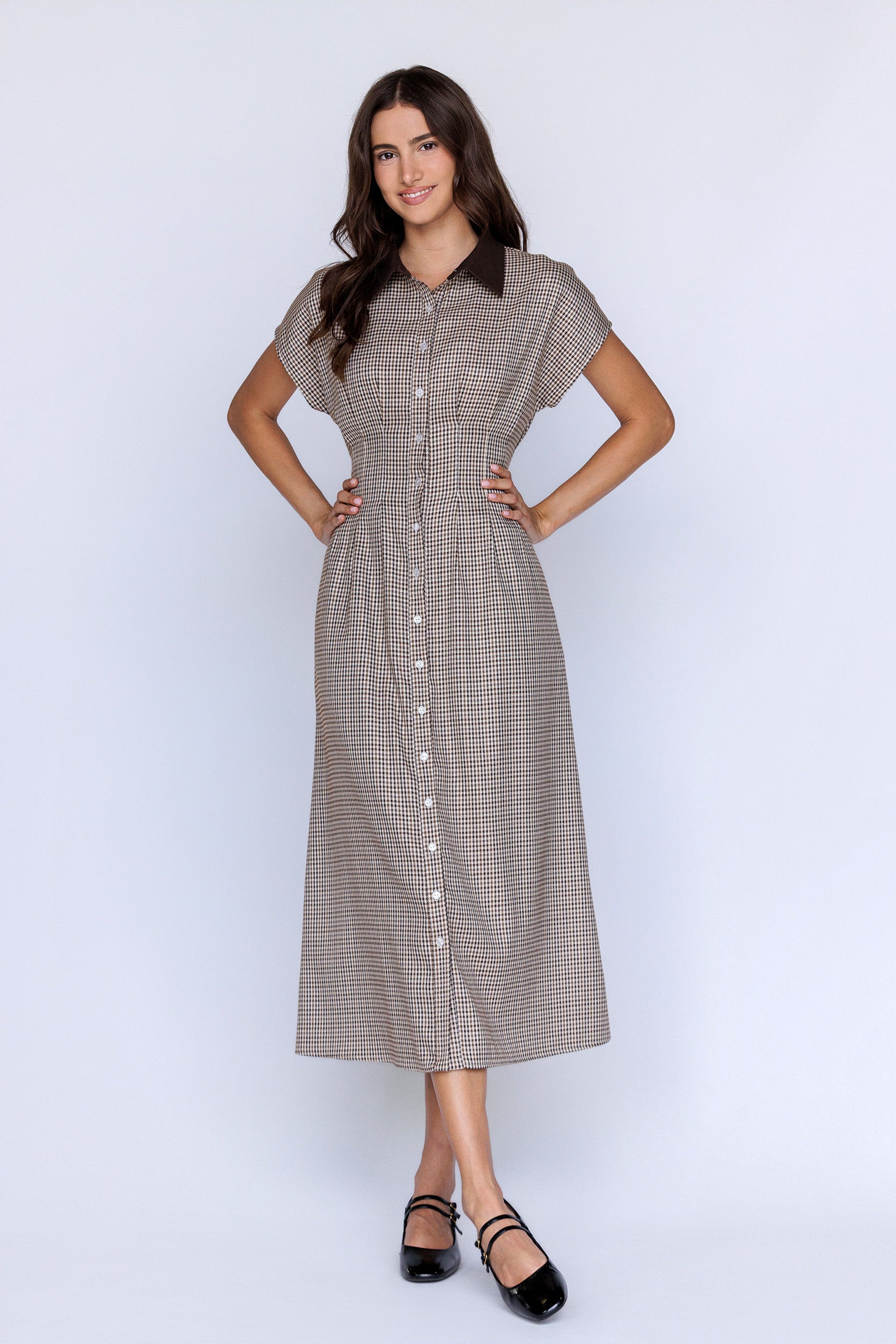 Woman wearing a brown checkered dress on a white background