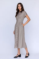 Side view of a woman wearing a checkered dress on a white background