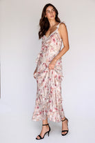 Side view of a model wearing wearing a floral dress against a white background