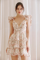 Blush floral ruffle mini dress with V-neckline, flutter sleeves, and tiered skirt