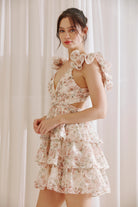 Side view of blush floral ruffle mini dress with V-neck and layered hem