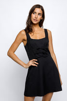 Woman wearing a black dress against a white background