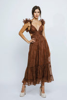 Woman wearing a brown dress with floral details on a white background