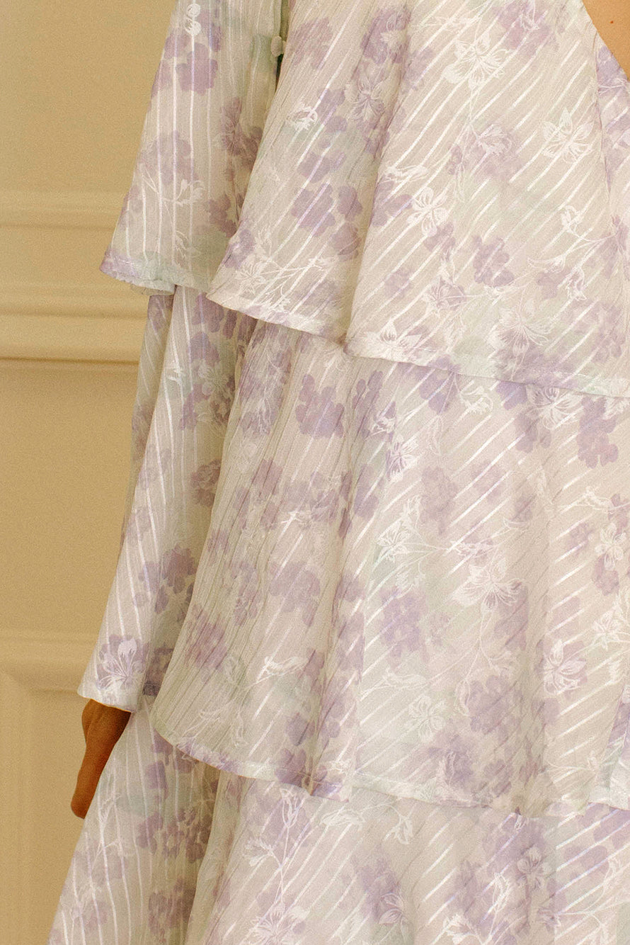 Lavender slip dress with floral and stripe pattern against a beige wall