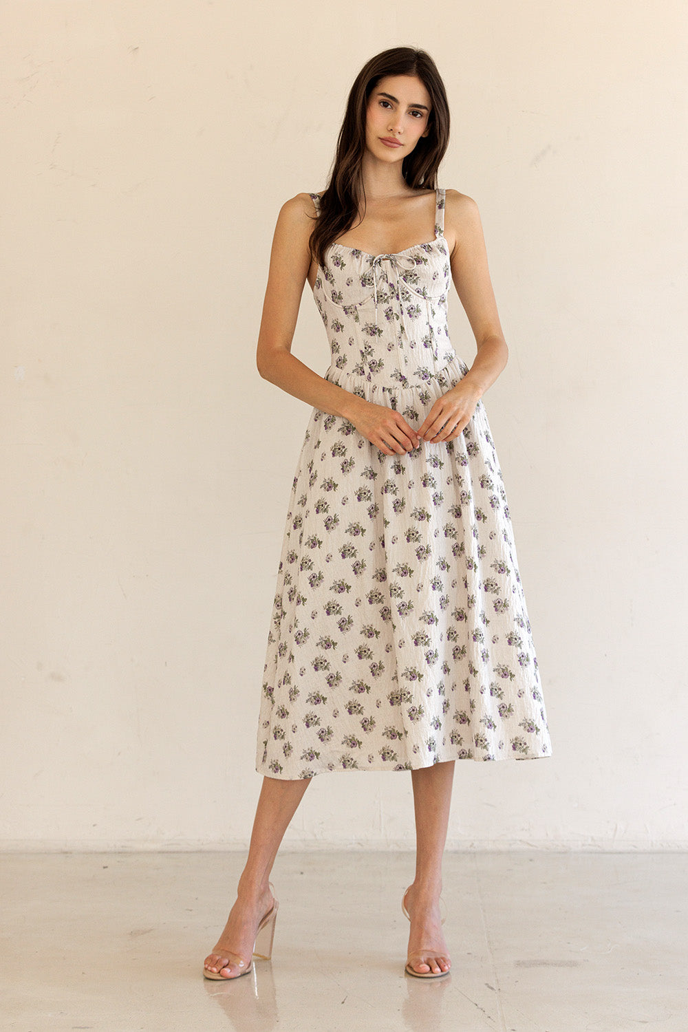 Woman wearing a floral dress against a plain background