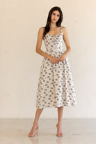 Woman wearing a floral dress against a plain background