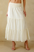 Cream maxi skirt with a subtle checkered pattern worn by a person on a beige background