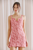 Woman wearing a pink and red bodycon dress against a plain background