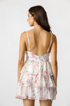 This image features a stylish women's dress with the model showcasing the back view. The dress, identified by the code JD5638VT, is adorned with a delicate, floral print design in soft hues, creating a charming and feminine appearance.