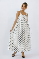 Woman wearing a polka dot dress and black high-heels on a white background
