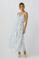 Woman wearing a light blue floral maxi dress on a white background