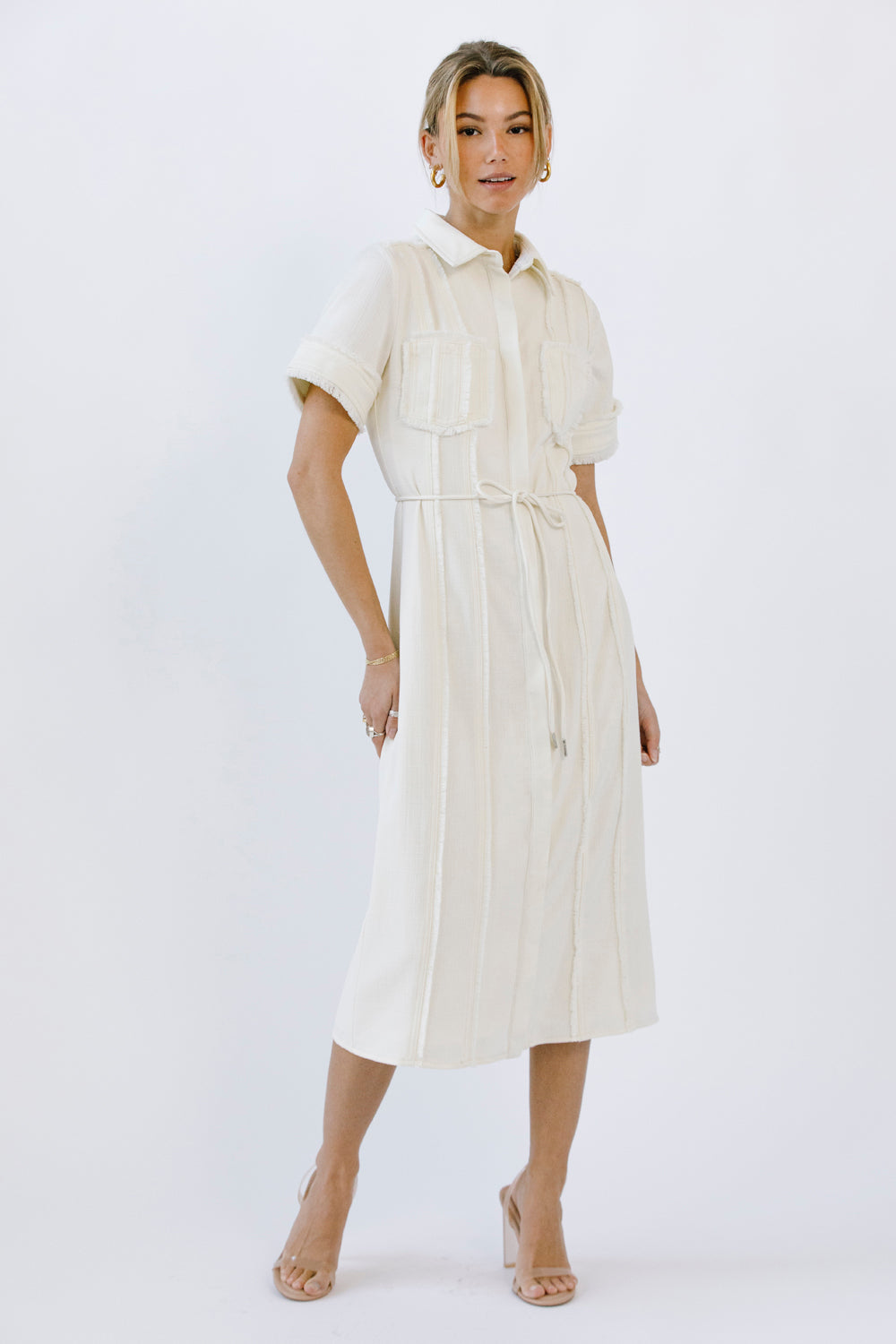 Woman wearing a cream dress on a white background