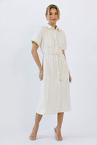 Woman wearing a cream dress on a white background