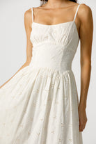 Cream dress with intricate detailing on a plain background