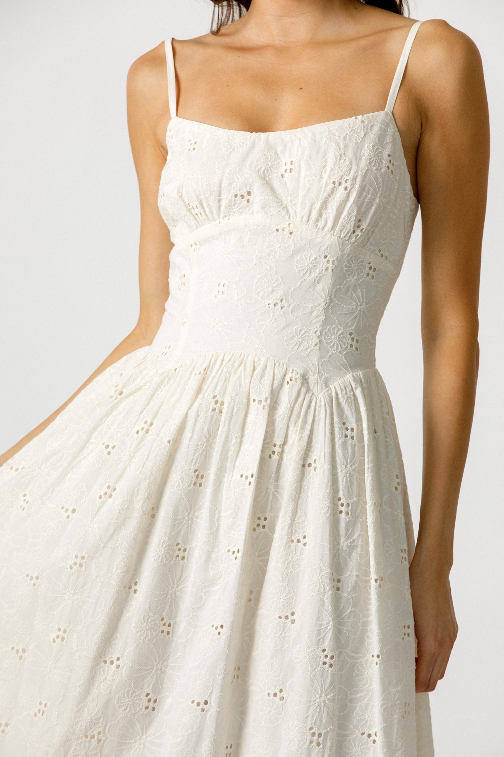 Cream dress with intricate detailing on a plain background