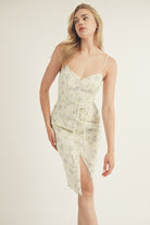 Woman wearing a floral slip dress on a plain background