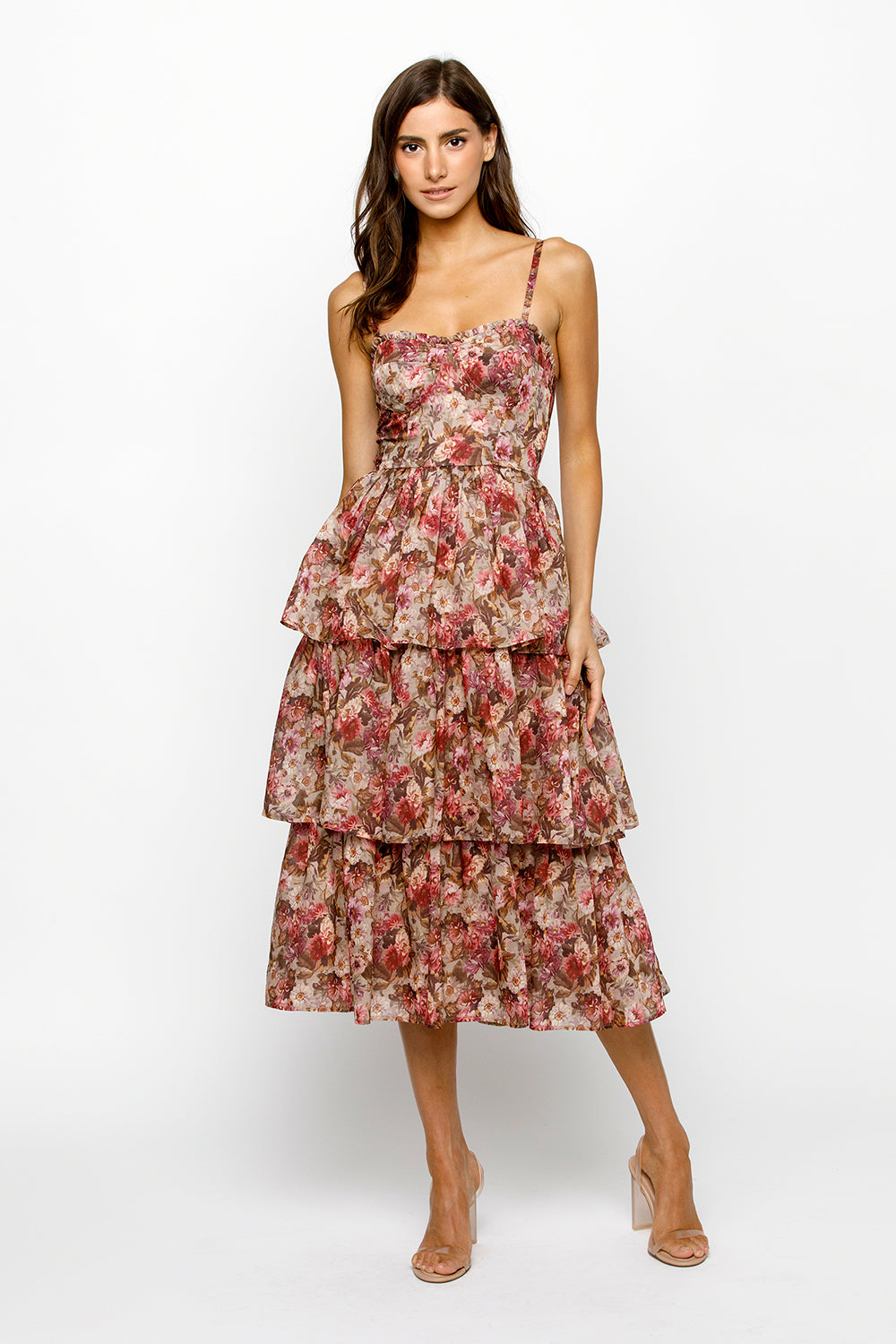 Woman wearing a floral tiered dress on a white background