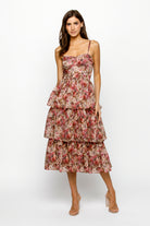 Woman wearing a floral tiered dress on a white background