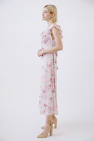 Side view of a woman wearing a purple floral dress on a white background