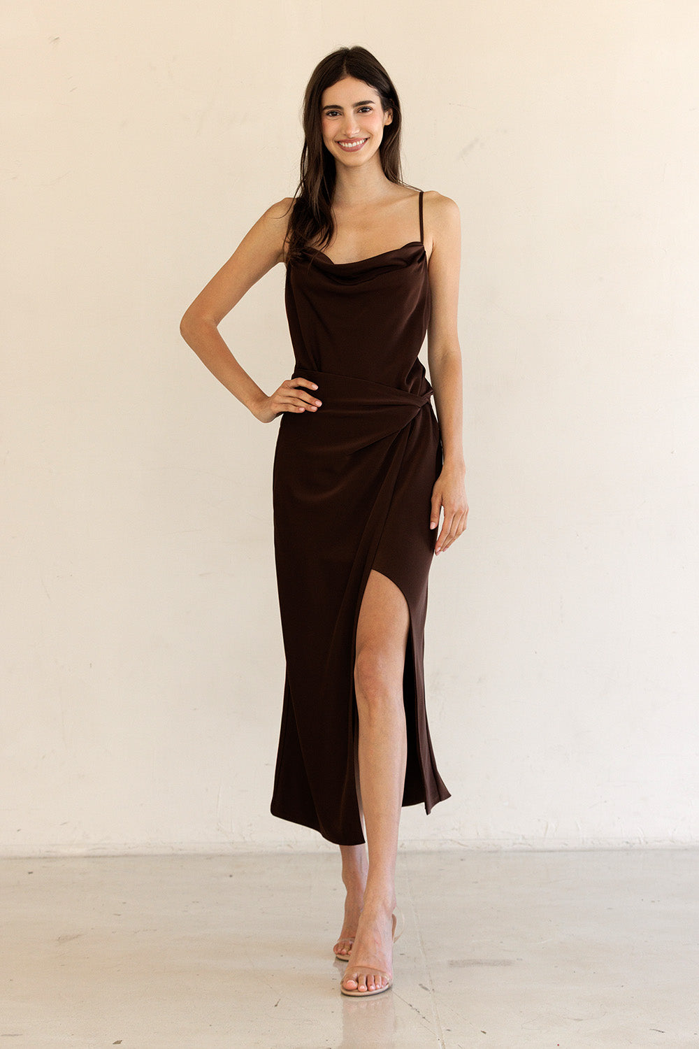 Woman wearing a brown dress with a plain background