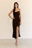 Woman wearing a brown dress with a plain background