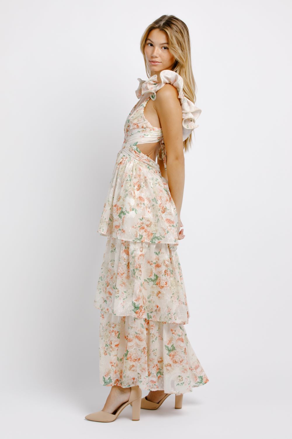 Woman wearing a floral dress with ruffled sleeves on a white background