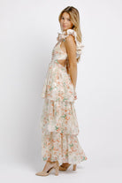Woman wearing a floral dress with ruffled sleeves on a white background
