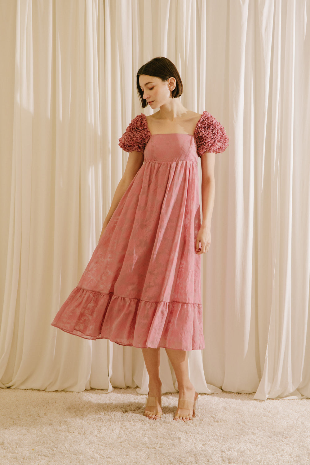 Woman wearing a pink dress with floral sleeves