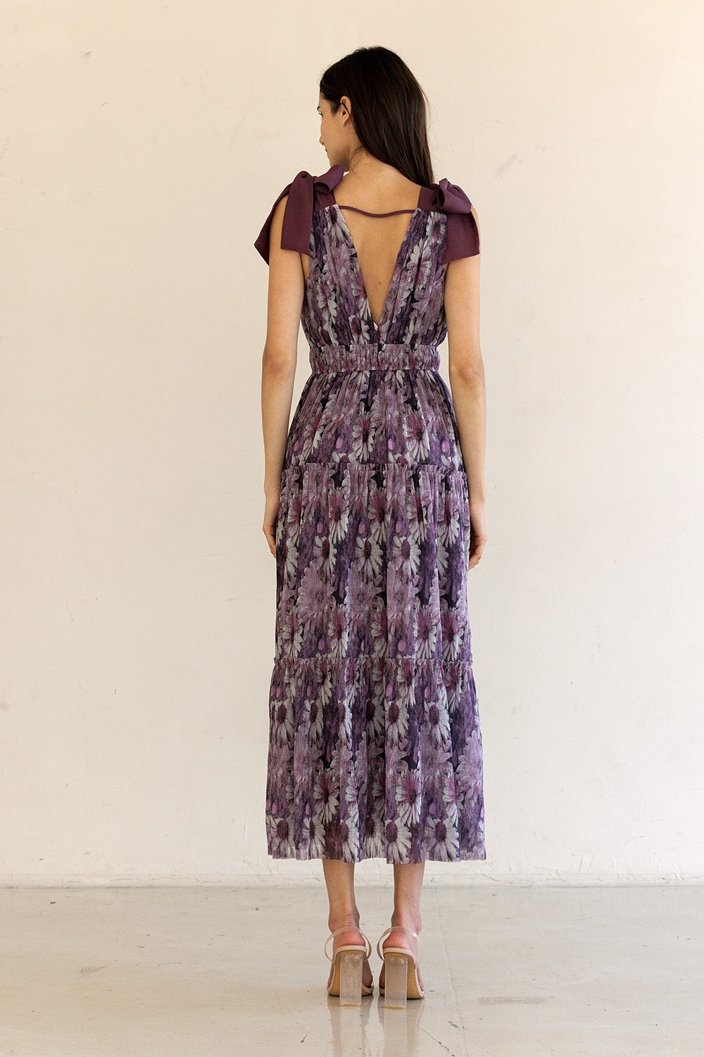 Woman wearing a purple floral dress with a white background